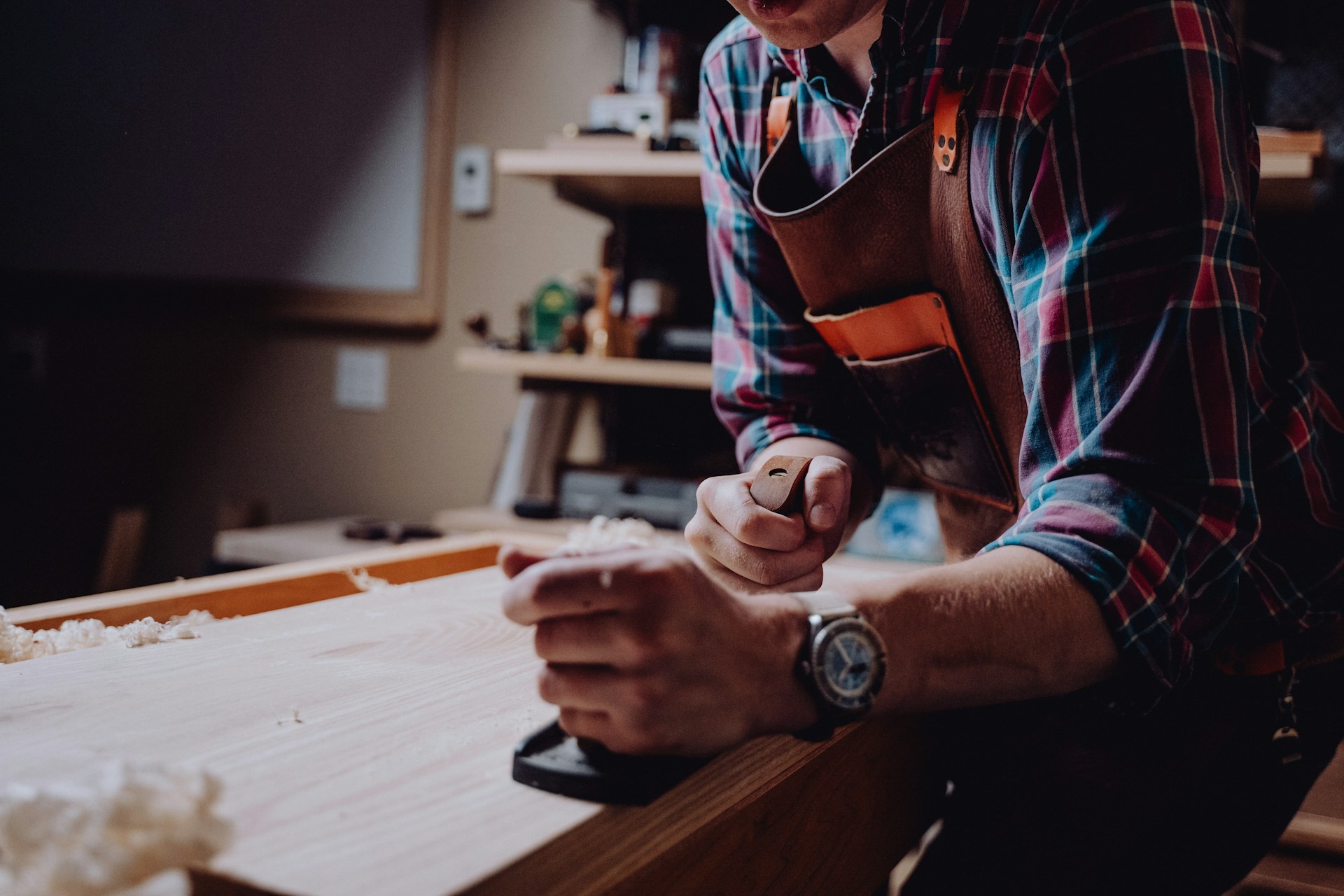 man working on a worktable with a woodworking plane