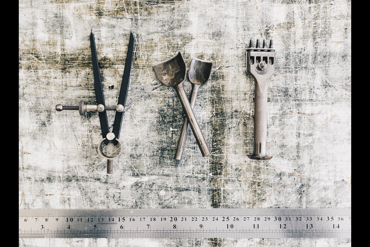Leather craft tools on a work table background. Leather craftmans work desk