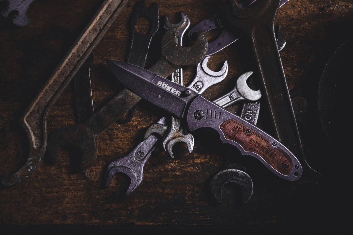 Rusty tools (knives, wrenches) on a wooden background
